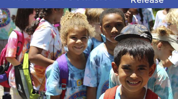 Children smiling with The NOLA Coalition logo. 